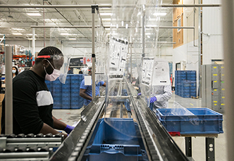 Photo of a worker in a PPE production faciltity