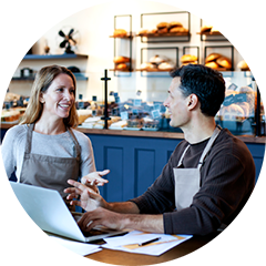 Photo of two employees talking in a small business bakery cafe.