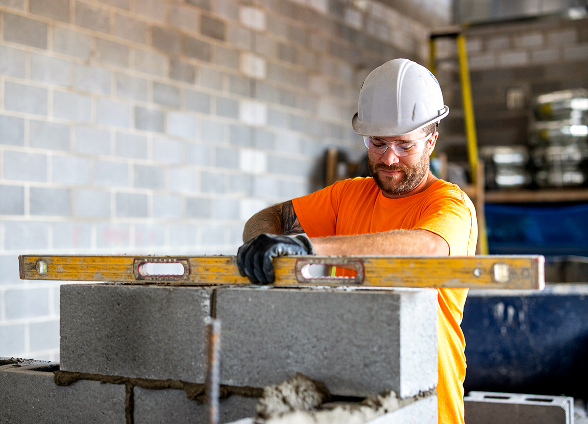 Photo of a construction worker on a construction site laying cement bricks in Toronto, Ontario.