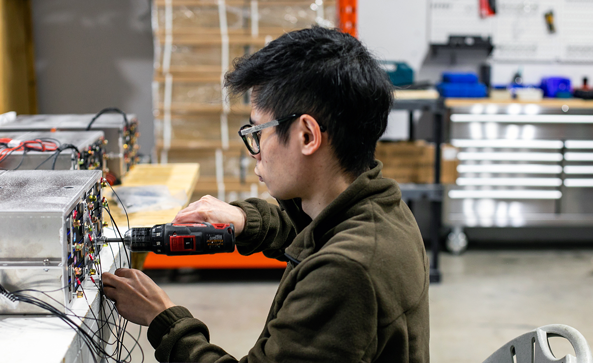 Photo of an employee at a workstation in a battery manufacturing facility in Etobicoke, Ontario.