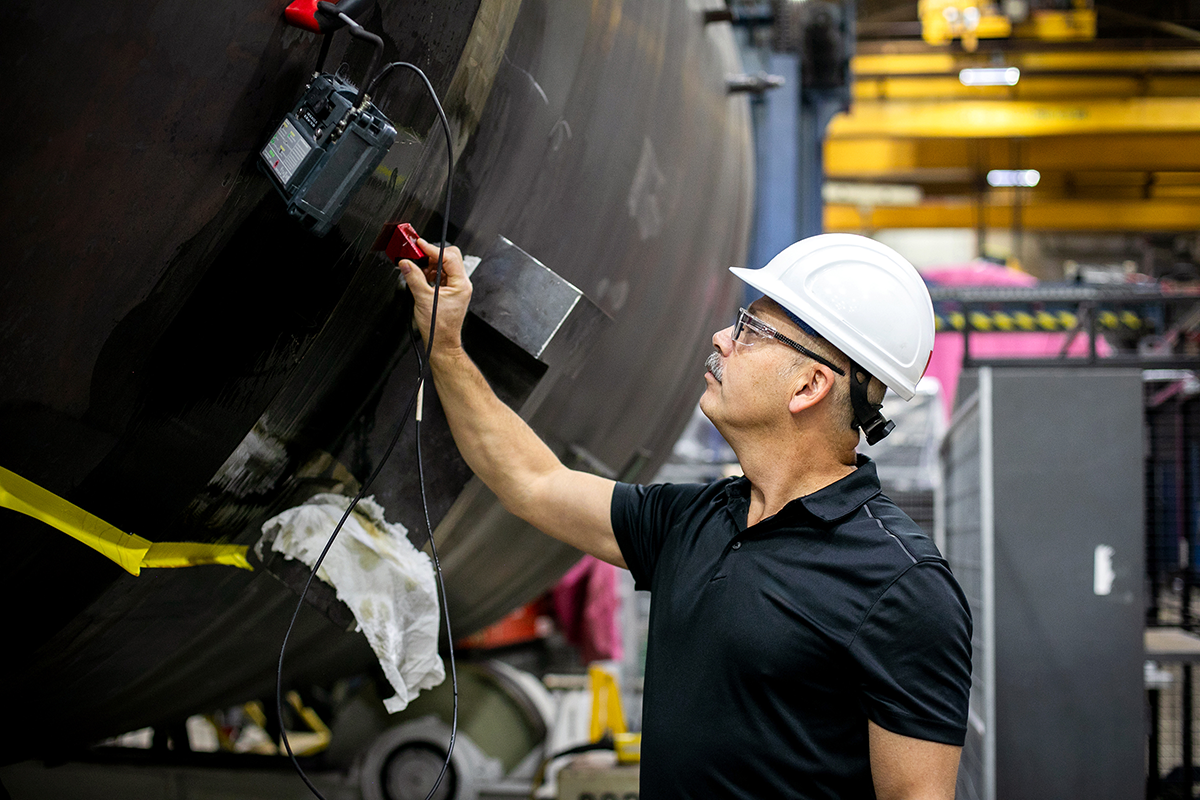 Photo of an employee working on parts in a nuclear industry manufacturing facility in Cambridge, Ontario.