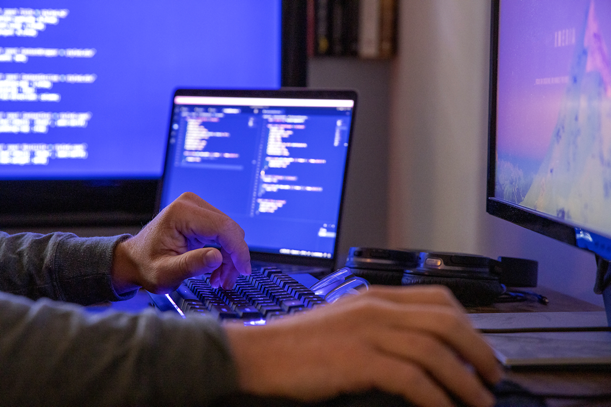 Photo of a person coding on a laptop.