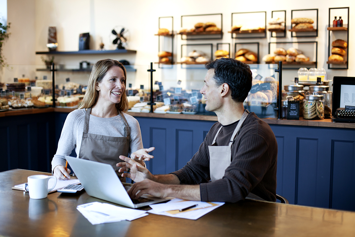 Photo of two employees talking in a small business bakery cafe.